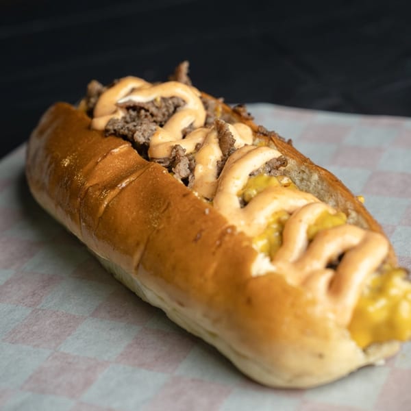 A Bricked Burgers cheesesteak sandwich with ground beef, cheese sauce, and special sauce on a bun.